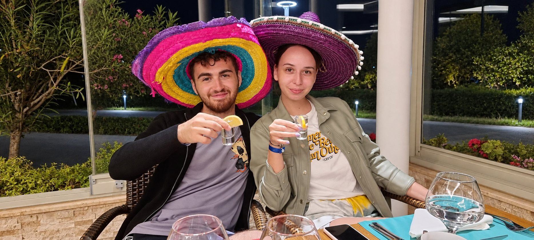 Cristi și Bianca cu pălării colorate, zâmbind